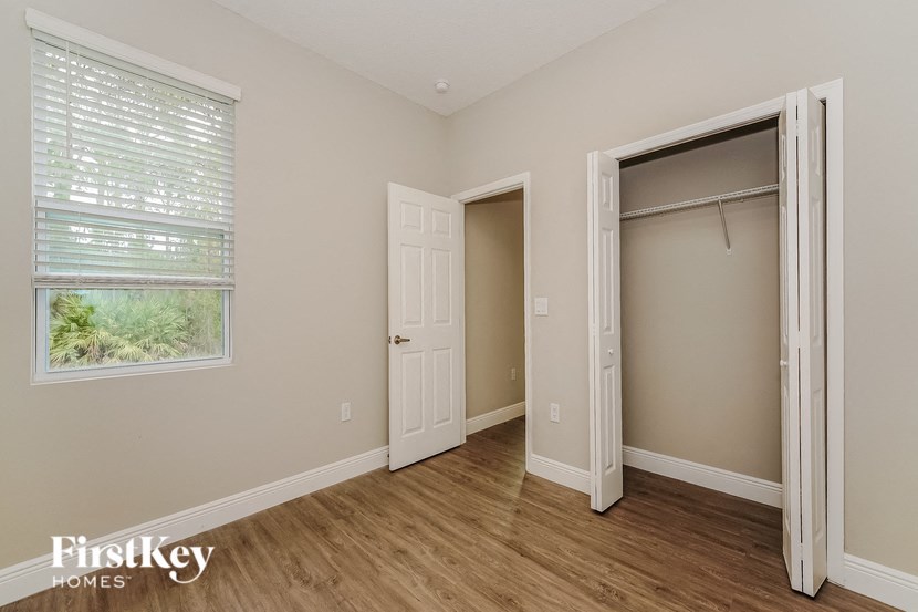 a bedroom with a closet and a window and a door to a closet