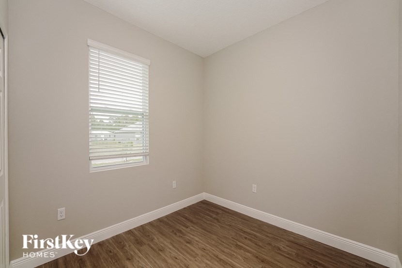 an empty room with wooden floors and a window