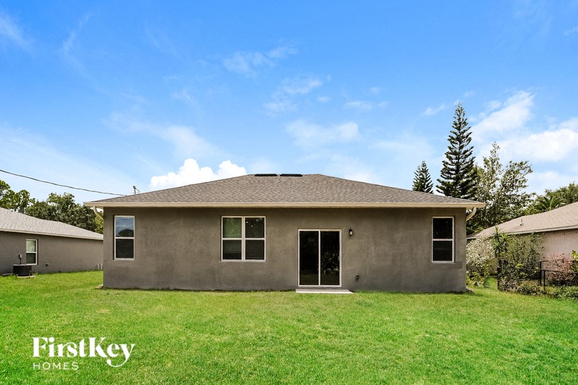 a small house with a grassy yard and a blue sky