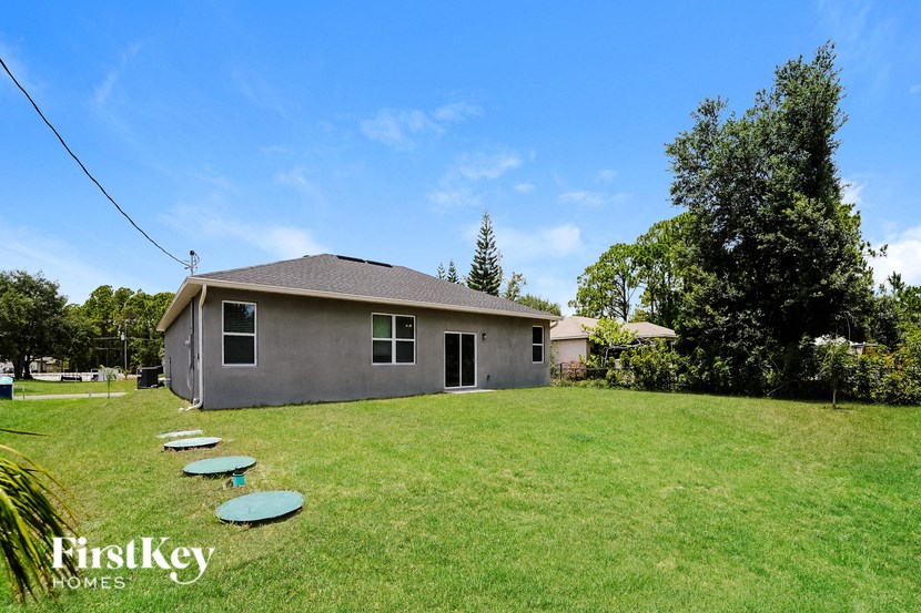 a backyard with a house and four frisbees on the grass