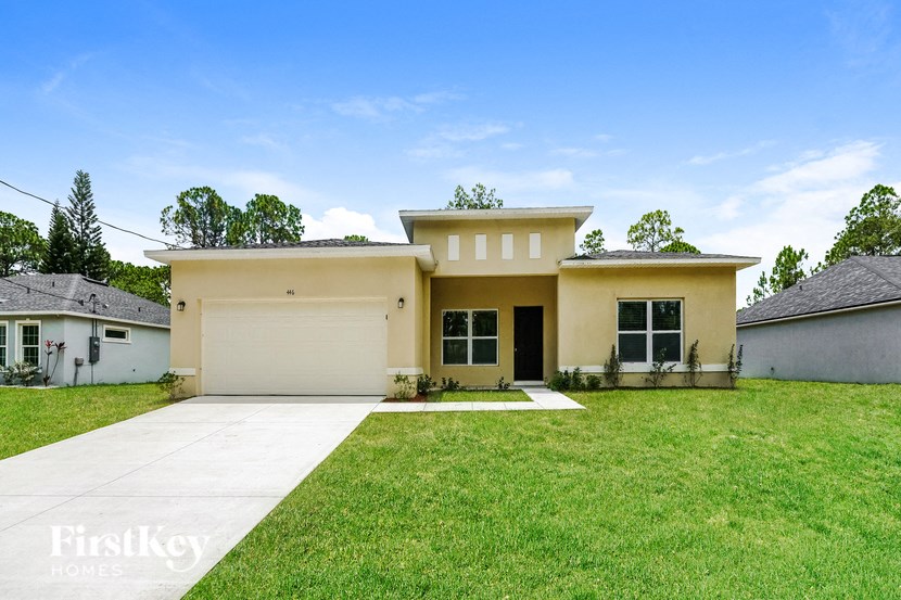 a yellow house with a lawn and a garage door