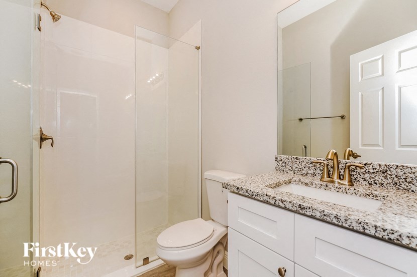 a white bathroom with a shower toilet and sink