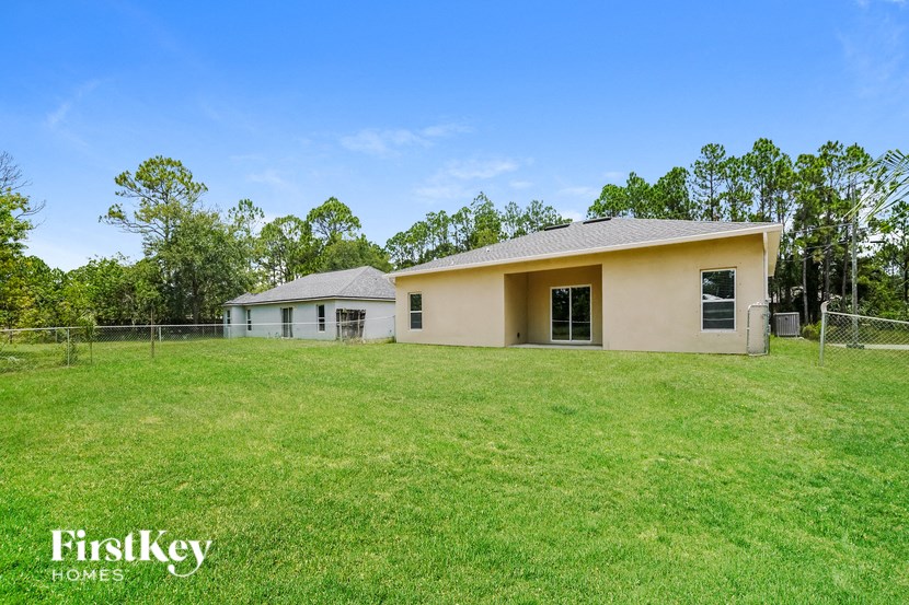 a house with a large grassy yard and a fence