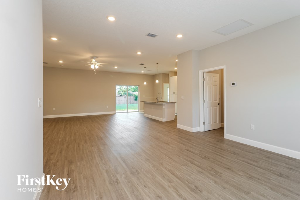 A spacious room with wooden flooring and a large window.