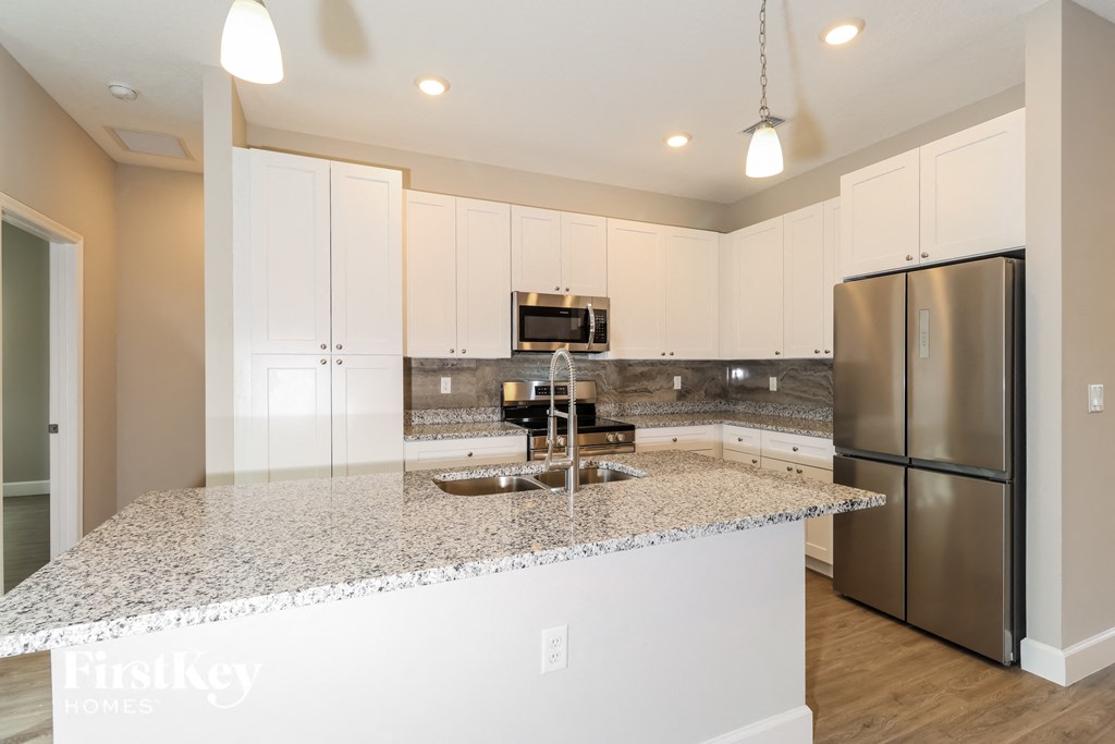 A kitchen with granite countertops and stainless steel appliances.