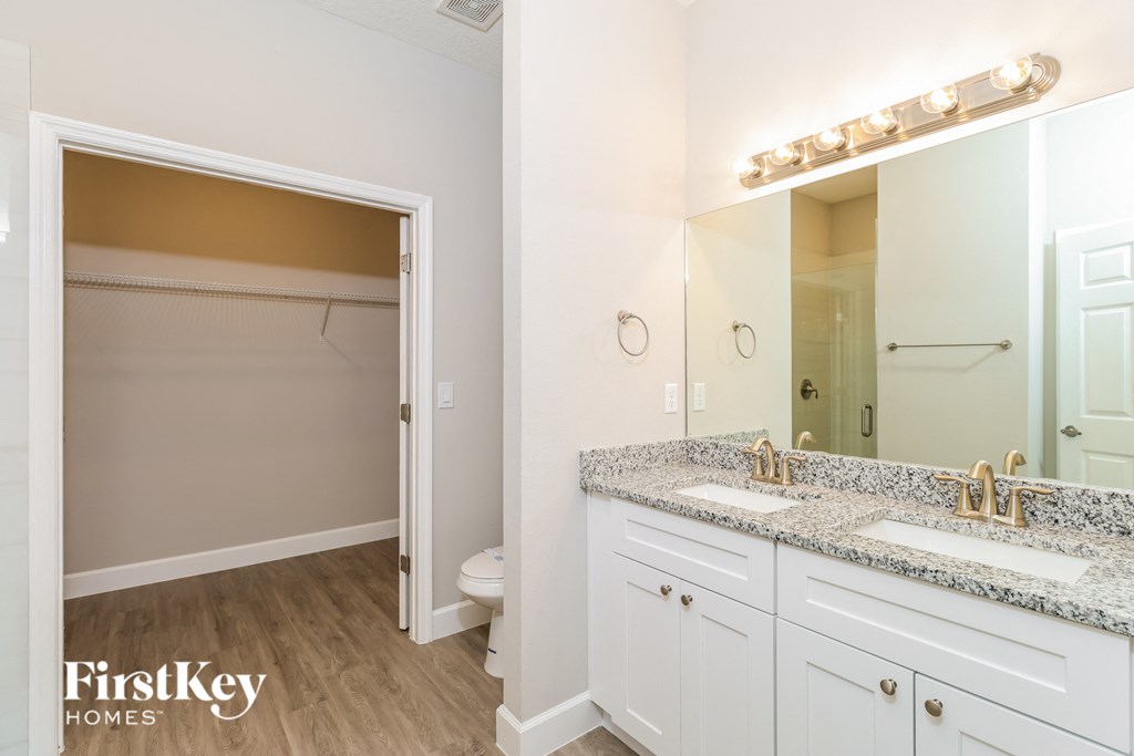 A bathroom with a white vanity and a white toilet.