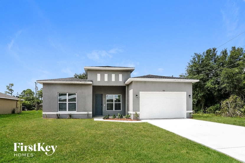 a gray house with a lawn and a garage