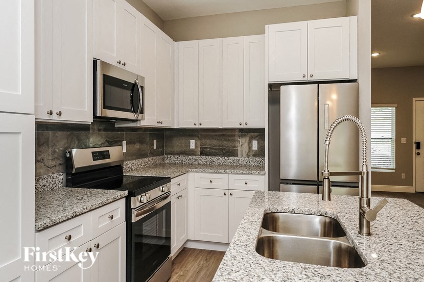 a kitchen with granite counter tops and white cabinets