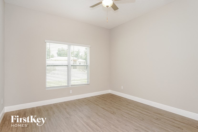 the second bedroom with wood floors and a ceiling fan