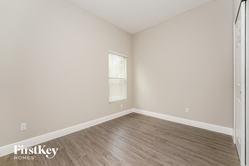 the spacious living room with wood flooring and a window