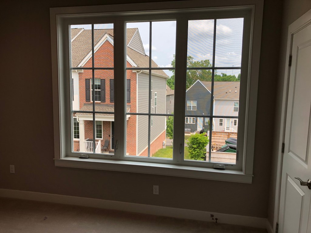 a large window in a room with a view of a brick house