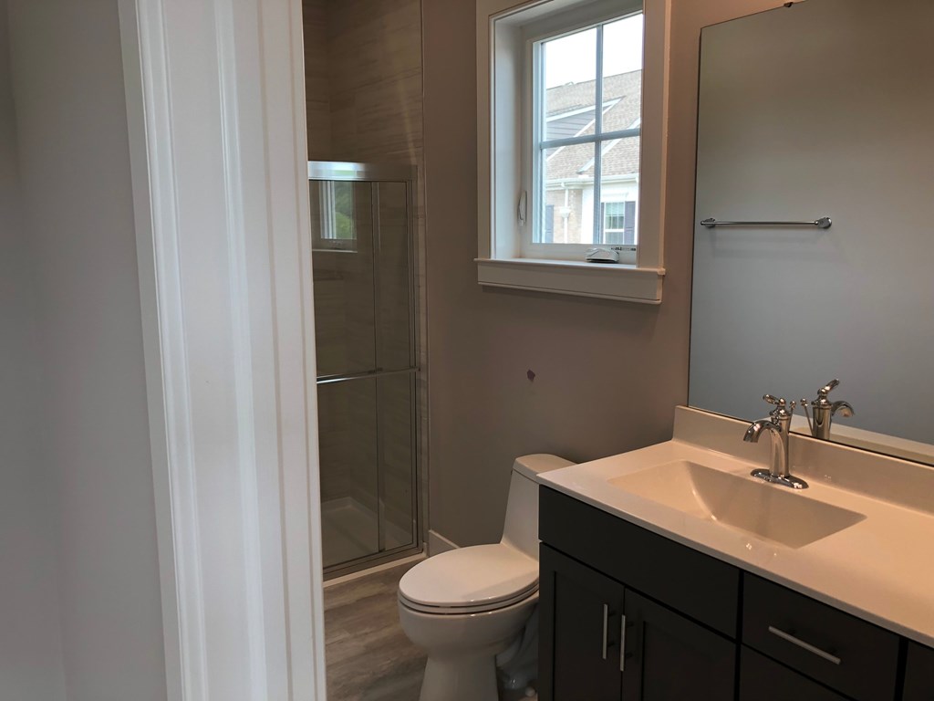 a bathroom with a toilet and a sink and a shower