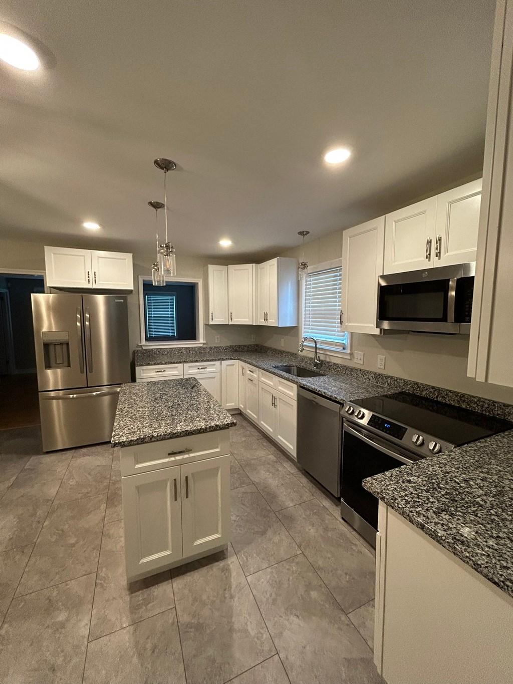 A kitchen with granite countertops and stainless steel appliances.