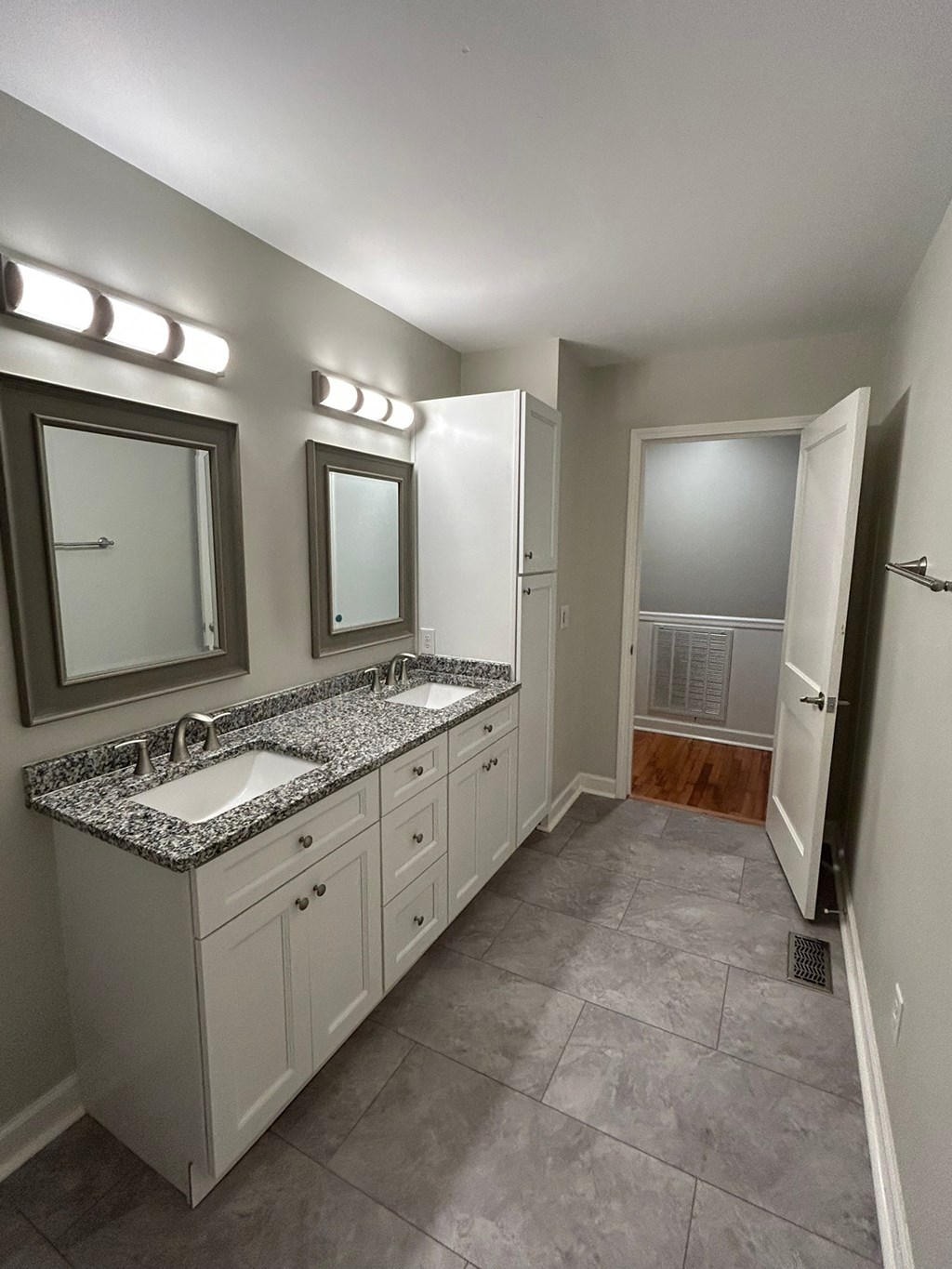 A bathroom with two sinks and a large mirror.