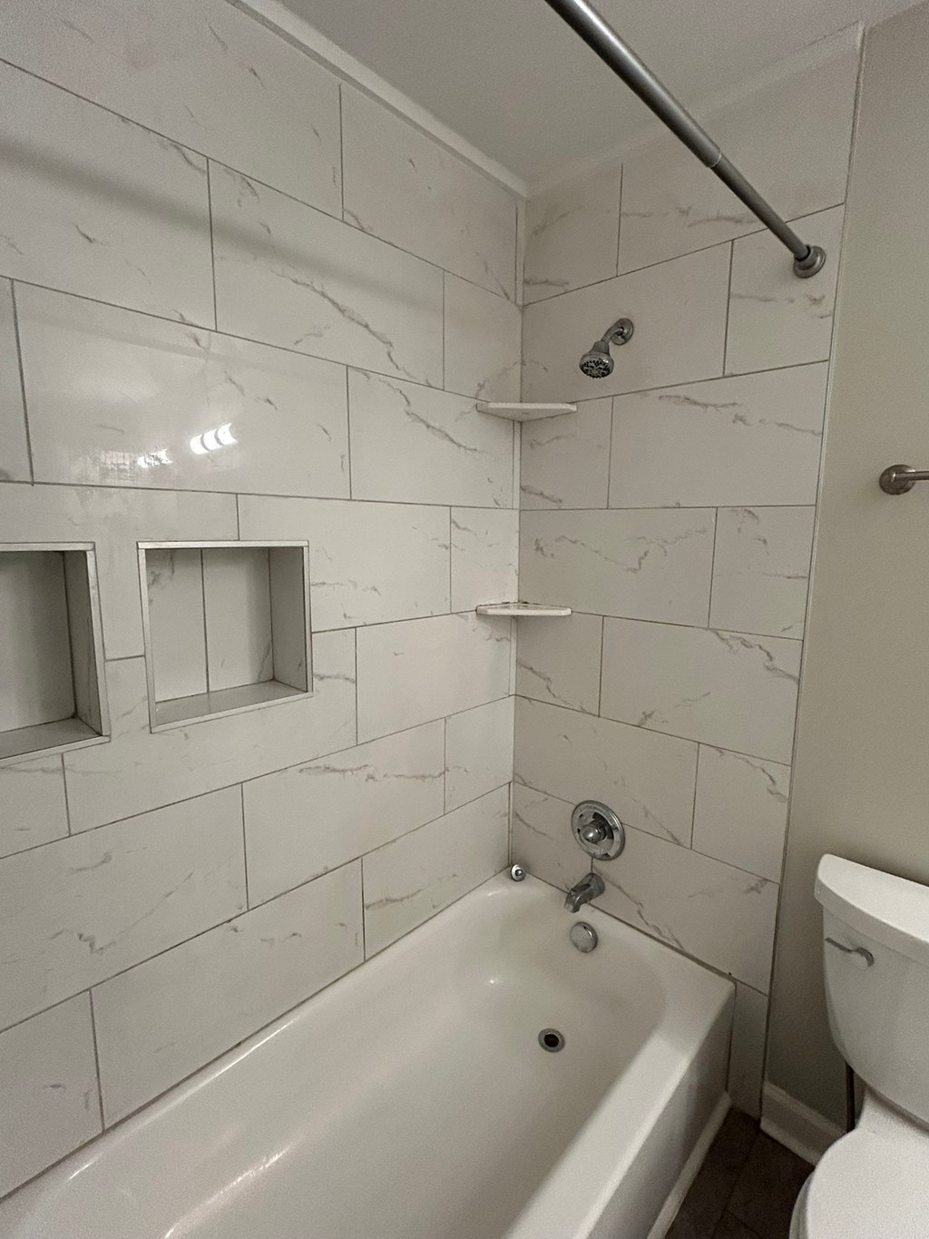 A white bathroom with a tub, toilet and sink.