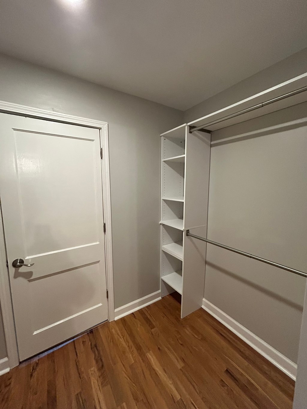 A white door is on the left and a white shelf is on the right.