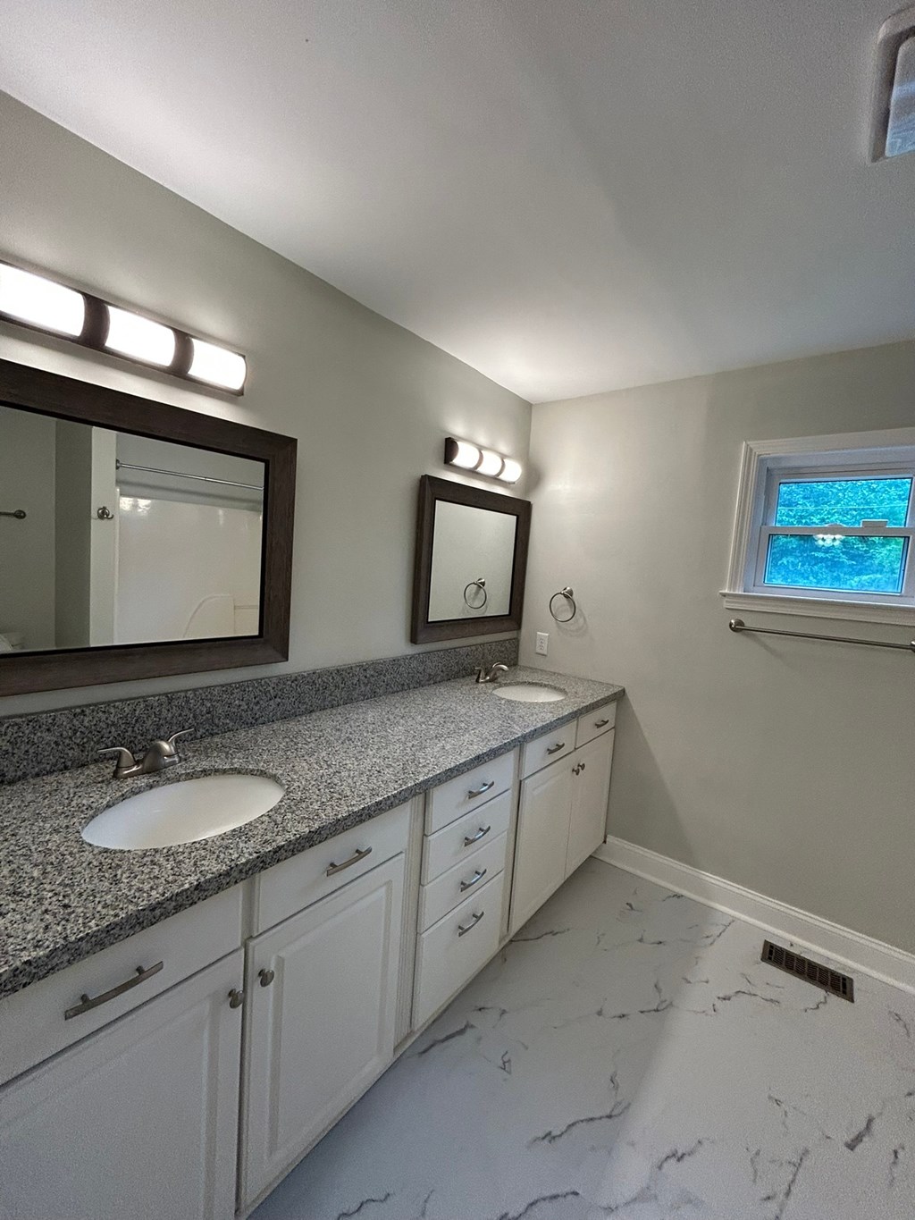 A bathroom with a sink, mirror, and a window.