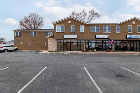 the front of a building with a parking lot