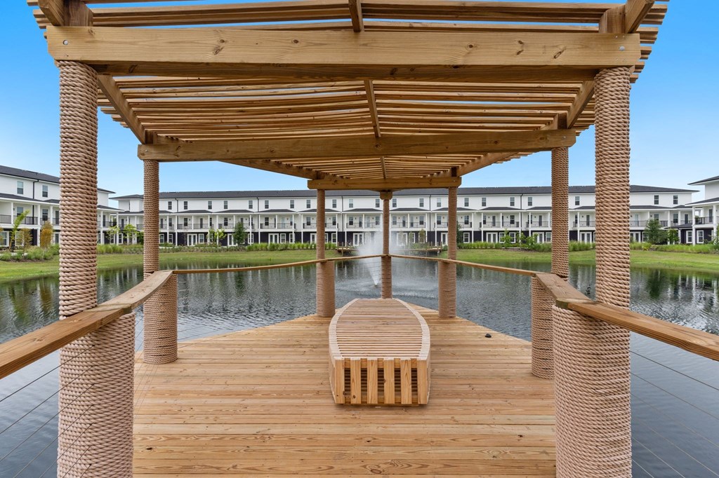 a covered dock with a bench on the water