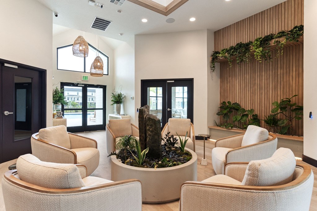 a lobby with chairs and a small garden in the middle