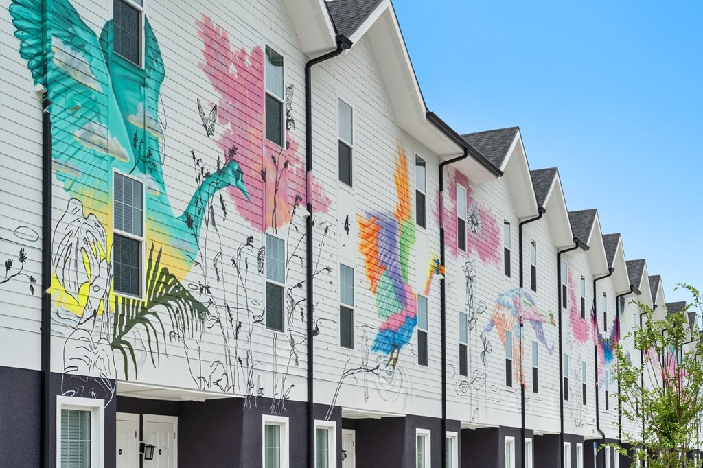 a row of colorful houses with graffiti on them