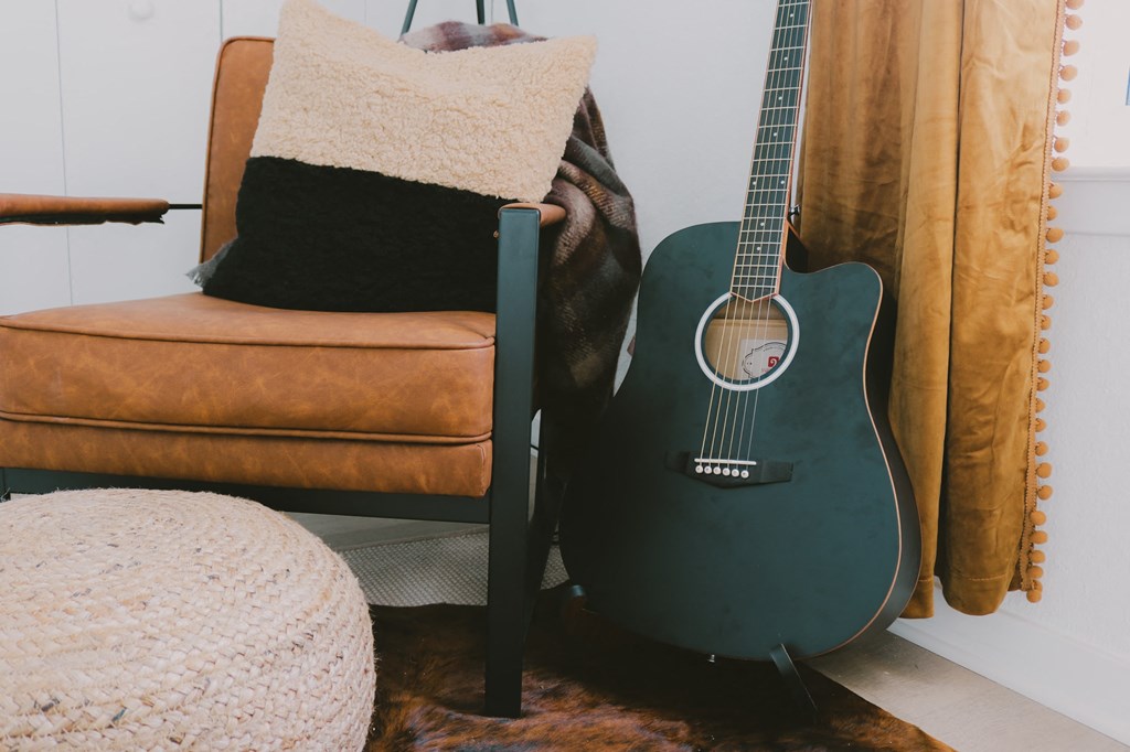 a guitar sitting next to a chair in a living room