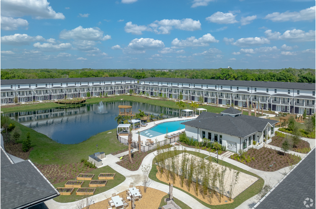 an aerial view of a resort with a pool and a lake