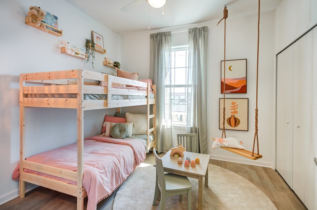 a bedroom with bunk beds and a swing in it