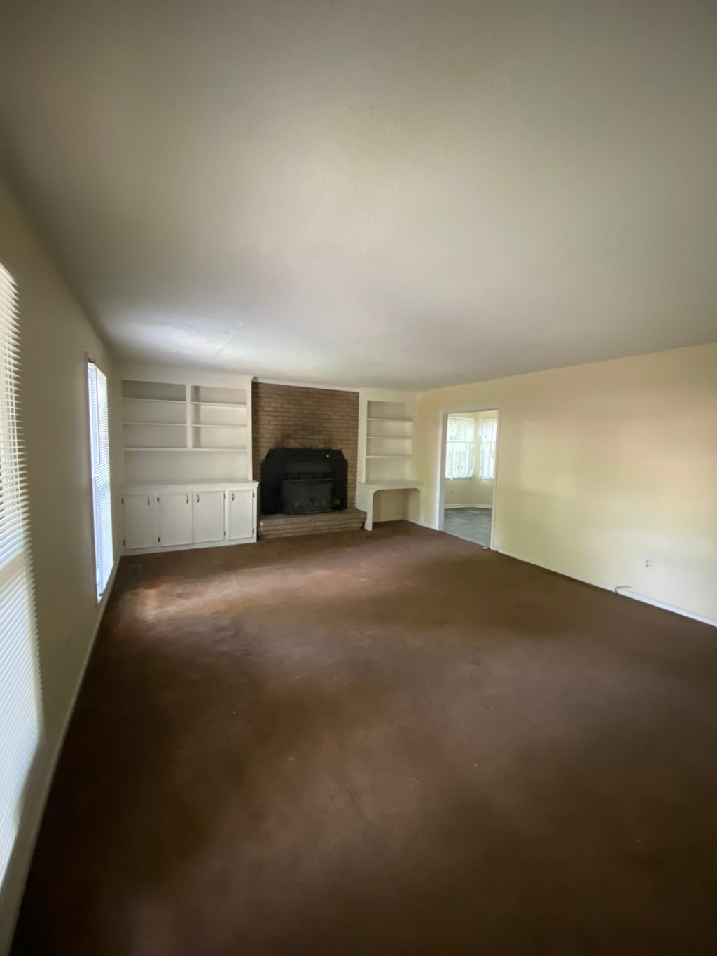 an empty living room with a couch and a window