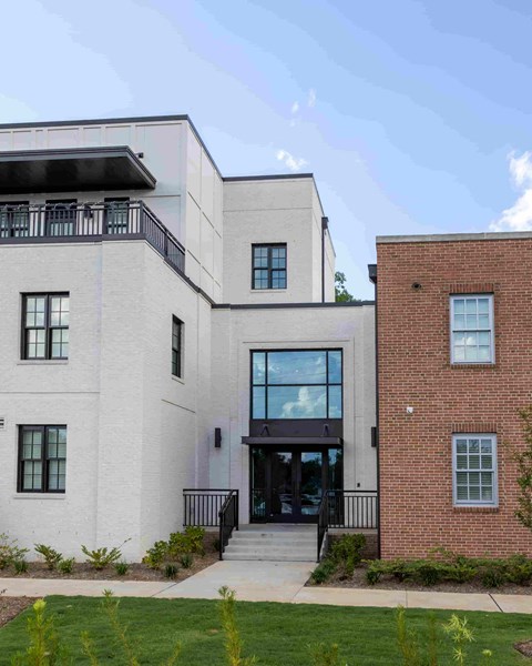 the front of a white building with a glass door
