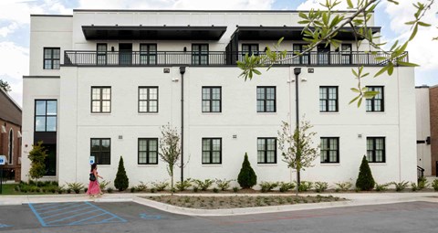 a white building with a woman walking in front of it