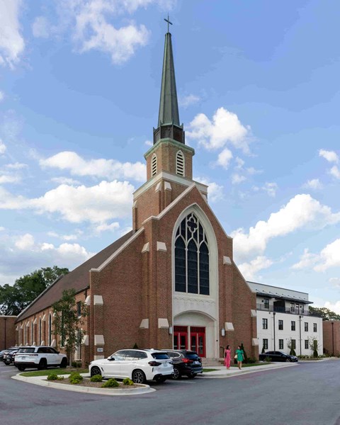 a church with a tall steeple on the corner of a street