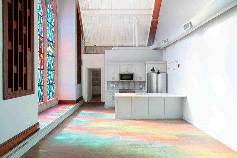 an open kitchen with white cabinets and a large window