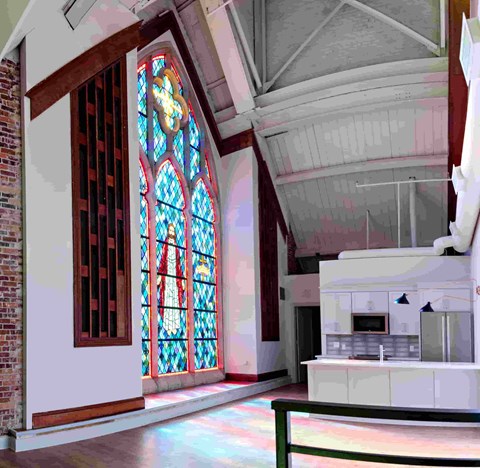 a room with a large stained glass window and a kitchen