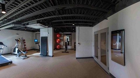 a workout room in a gym with weights and cardio equipment