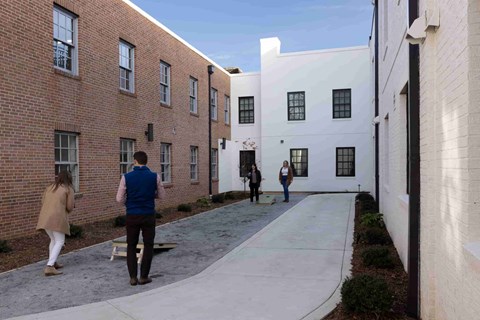a group of people walking through an alley between two buildings