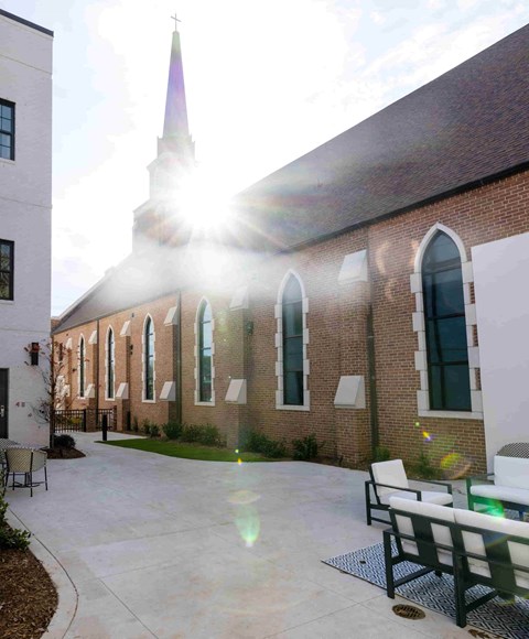 the courtyard of the church of the good shepherd with the sun shining through the building