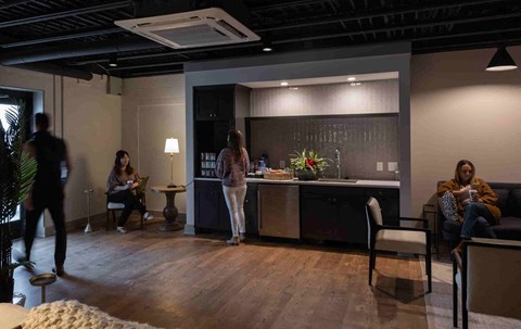a group of people in a room with a kitchen