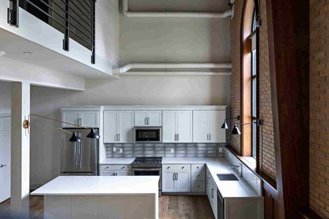 an open kitchen with white cabinets and a large window
