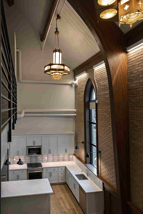 a kitchen with white cabinets and a large window