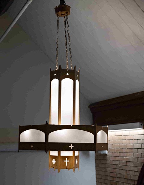 a chandelier with crosses hanging from the ceiling of a church