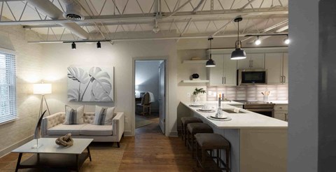 a view of a living room and a kitchen in a loft