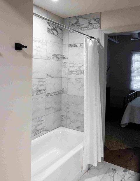 a bathroom with a tub and a shower curtain