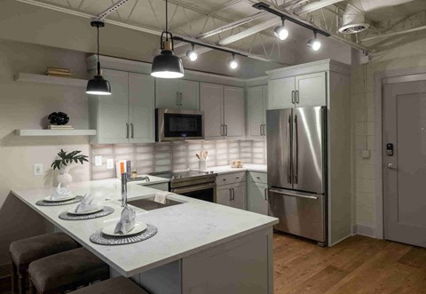 a kitchen with a island and stainless steel refrigerator