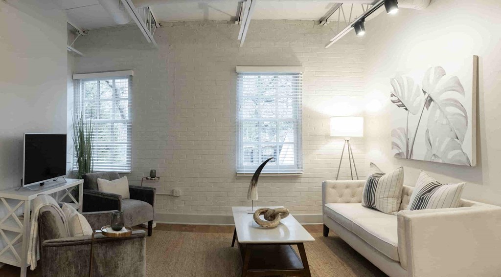 a living room with a white couch and a television