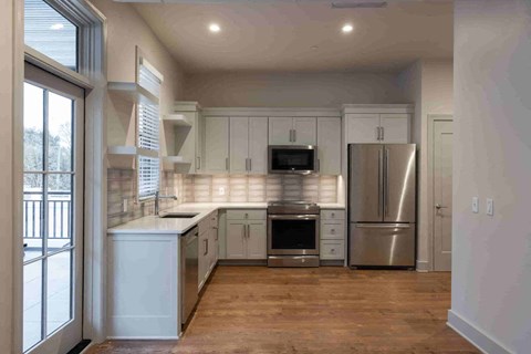 a kitchen with white cabinets and a stainless steel refrigerator