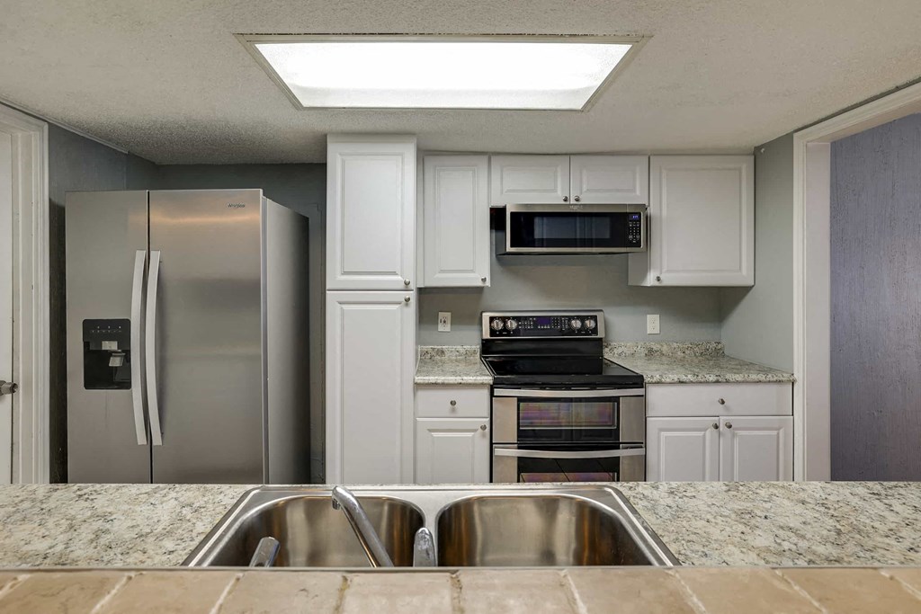 a kitchen with stainless steel appliances and granite counter tops