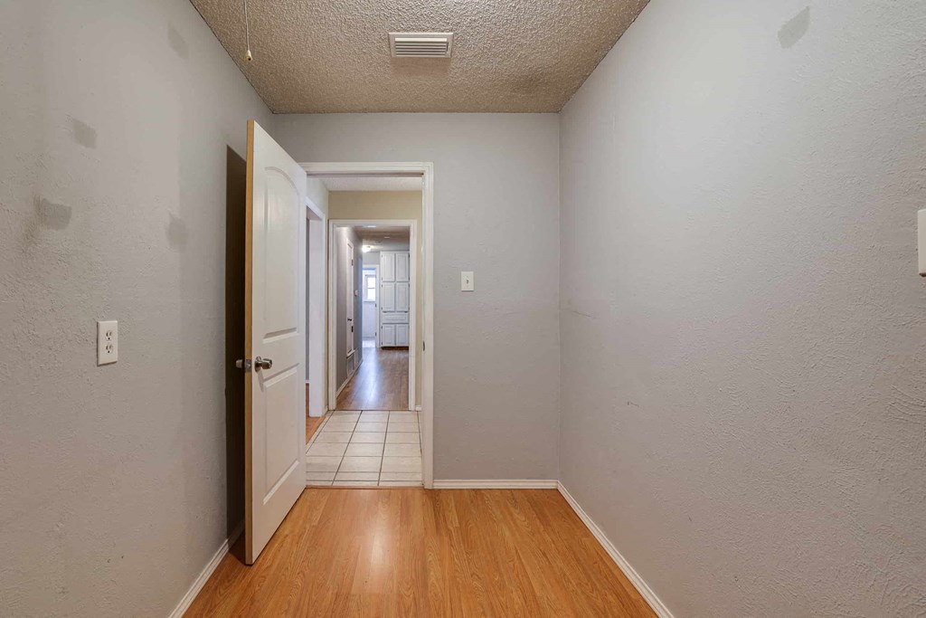 a room with a door open to a hallway with a tiled floor