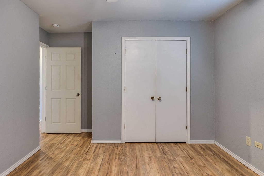 an empty room with two closets and a wooden floor