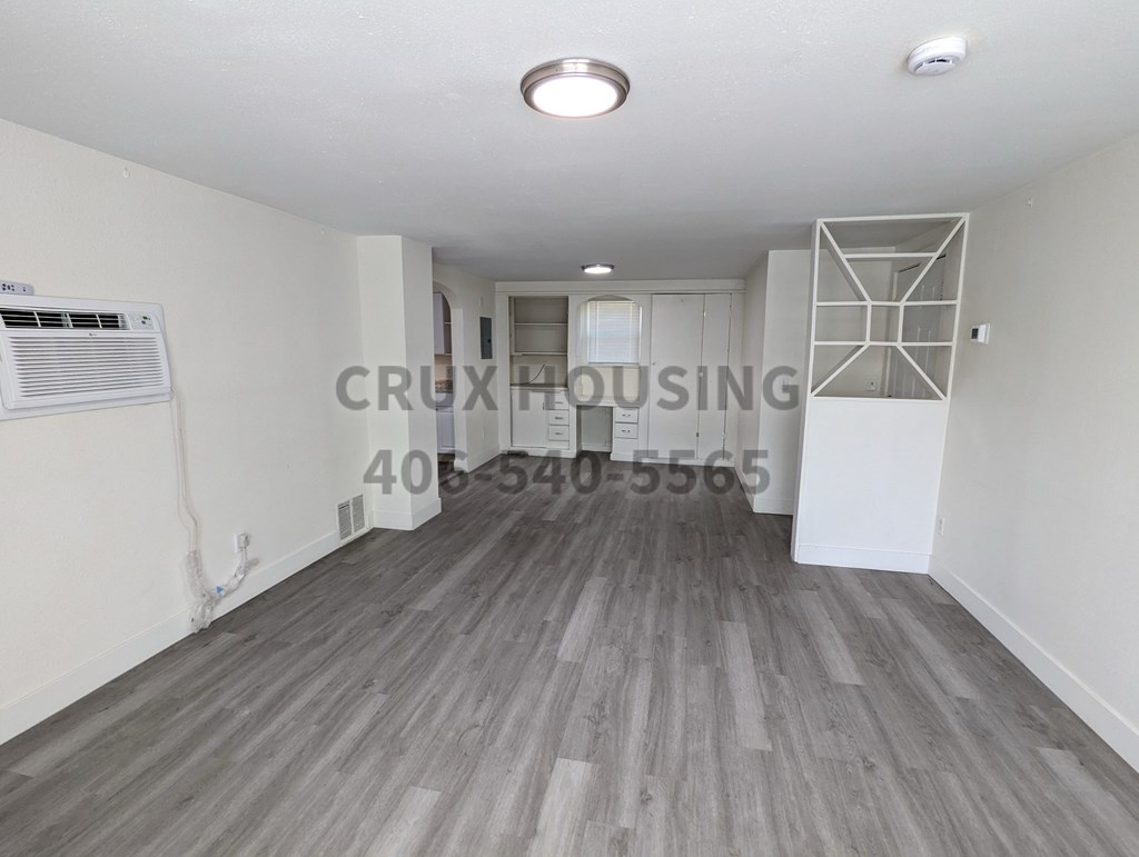A room with wooden flooring and a white ceiling with a light fixture.